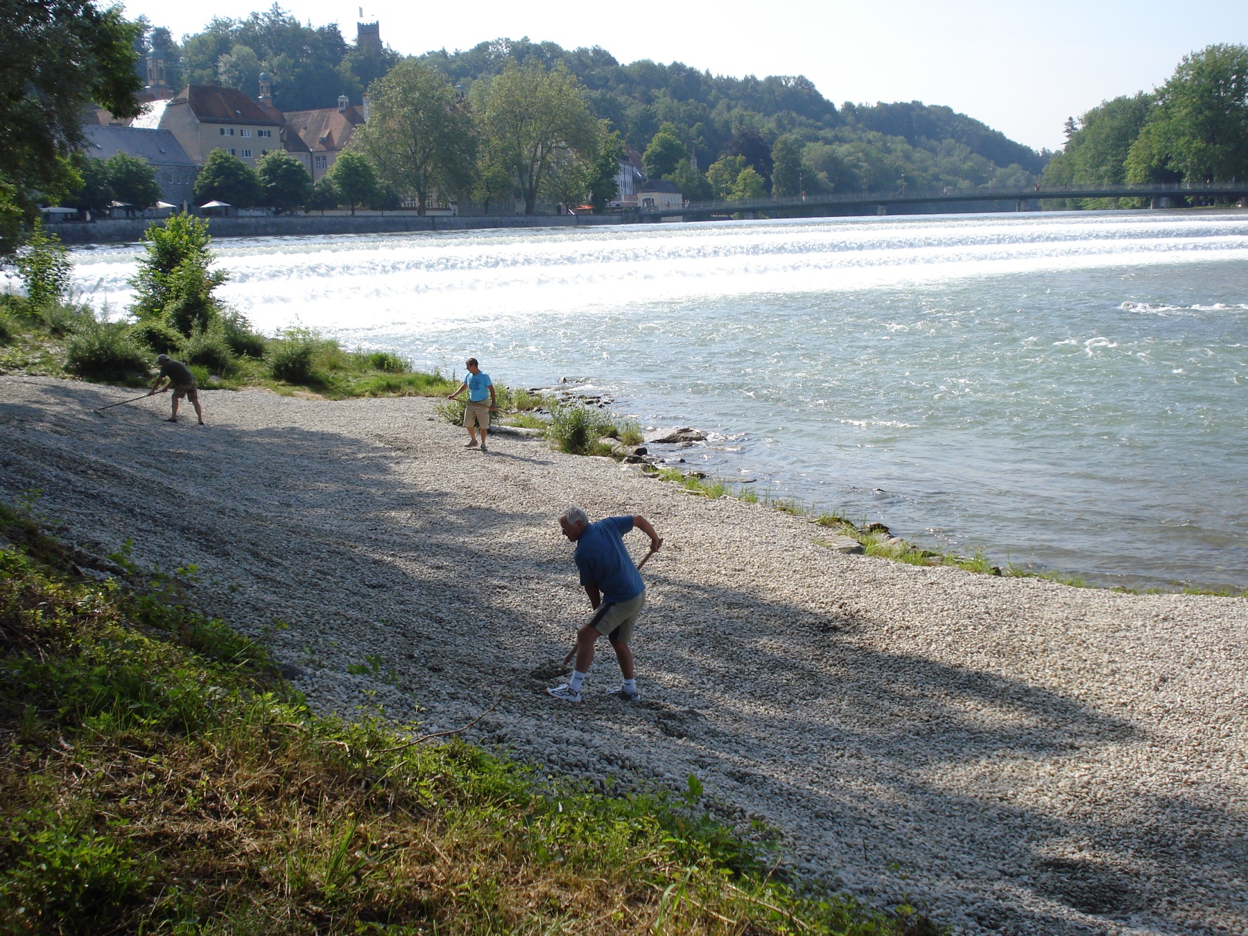 Helfer verteilen Kies am Lechstrand 2013